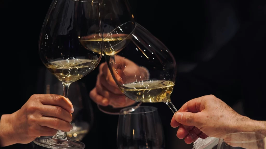 Goście wznoszący toast białym winem podczas imprezy okolicznościowej w Hotelu Gryf w Kościerzynie